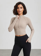 Woman wearing beige ribbed half-zip long-sleeve cropped yoga top, front view