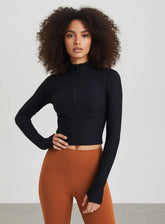 Woman wearing Black ribbed half-zip long-sleeve cropped yoga top, front view.