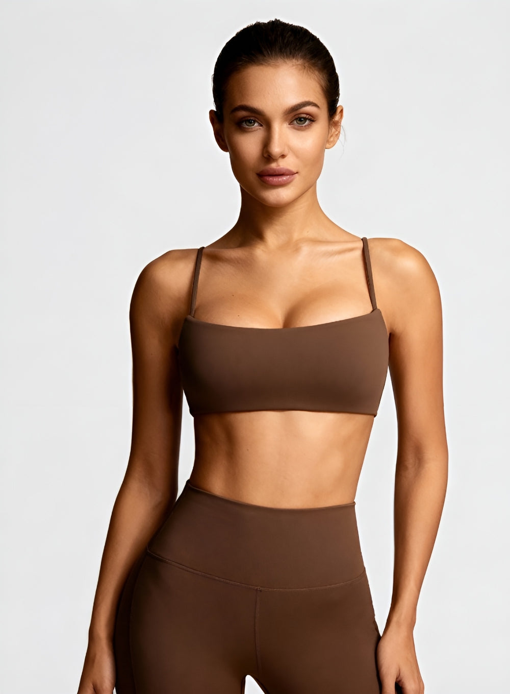 Woman wearing the CloudSense Seamless Sling Bra in black — open-back seamless sports bra with thin sling straps, sculpting fit, and smooth activewear fabric. | Vectorsportswear