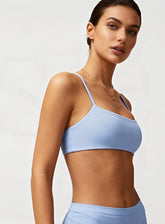 Woman wearing the CloudSense Seamless Sling Bra in black — open-back seamless sports bra with thin sling straps, sculpting fit, and smooth activewear fabric. | Vectorsportswear