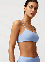 Woman wearing the CloudSense Seamless Sling Bra in black — open-back seamless sports bra with thin sling straps, sculpting fit, and smooth activewear fabric. | Vectorsportswear