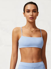 Woman wearing the CloudSense Seamless Sling Bra in black — open-back seamless sports bra with thin sling straps, sculpting fit, and smooth activewear fabric. | Vectorsportswear