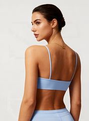 Rear view of model wearing black CloudSense Seamless Sling Bra — seamless open-back design with thin sling straps and sculpting performance fabric. | Vectorsportswear