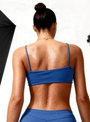 Rear view of model wearing black CloudSense Seamless Sling Bra — seamless open-back design with thin sling straps and sculpting performance fabric. | Vectorsportswear