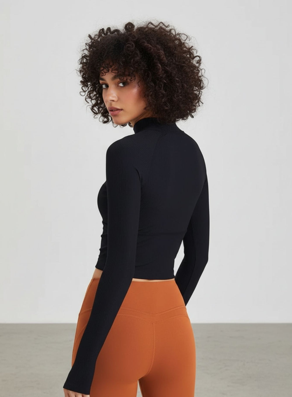 Back view of red ribbed cropped yoga top with raglan sleeves and thumbholes.