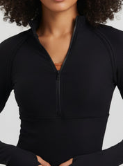Close-up of Black ribbed half-zip mock-neck yoga top, breathable quick-dry fabric.