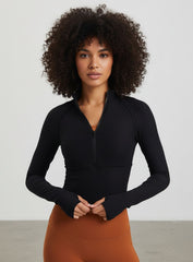 Black ribbed half-zip long-sleeve cropped women’s yoga top with thumbholes.