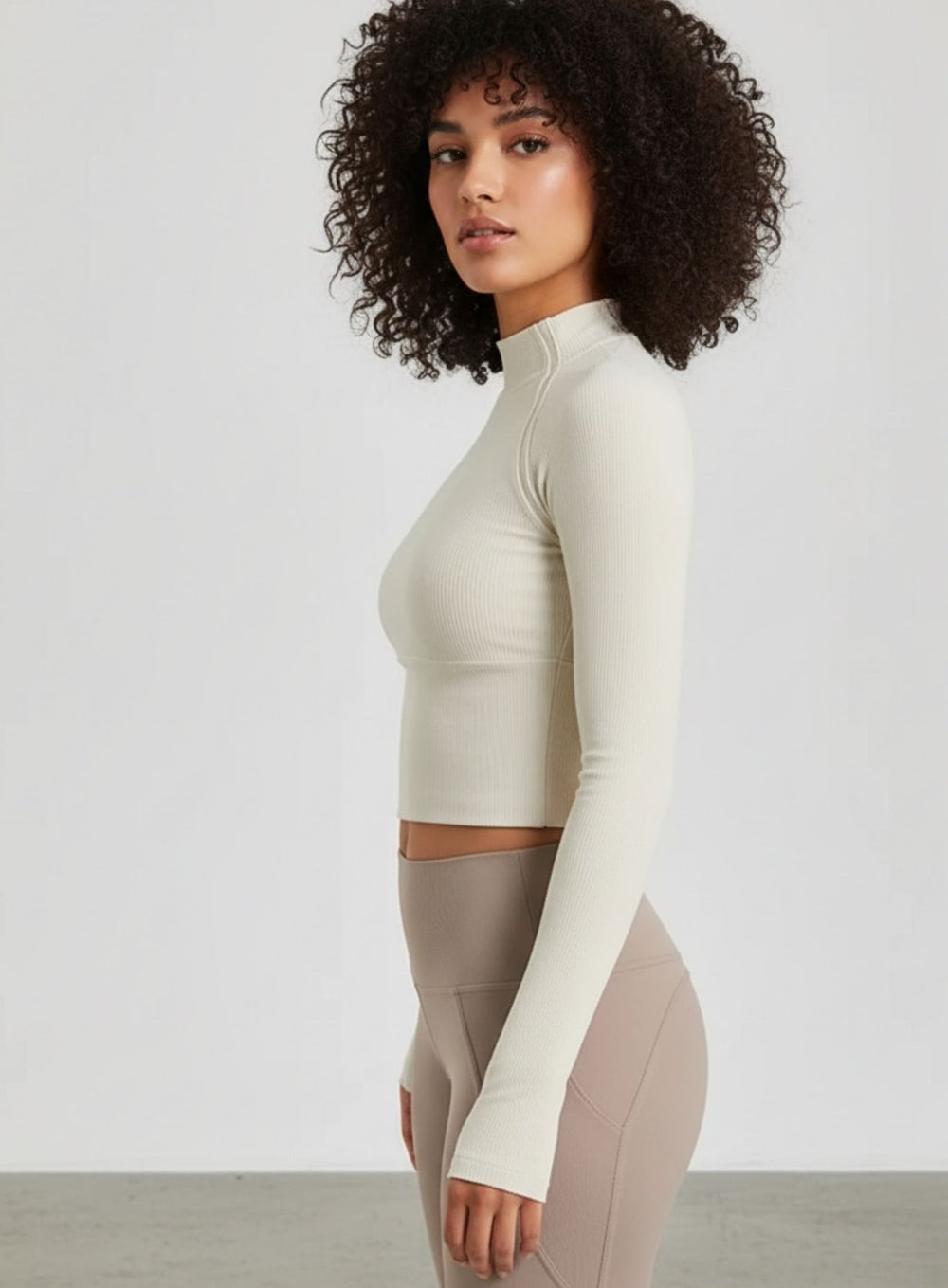 Ivory ribbed half-zip long-sleeve cropped women’s yoga top with thumbholes.