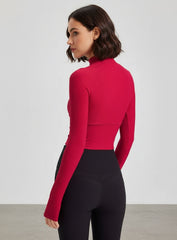 Back view of red ribbed cropped yoga top with raglan sleeves and thumbholes.