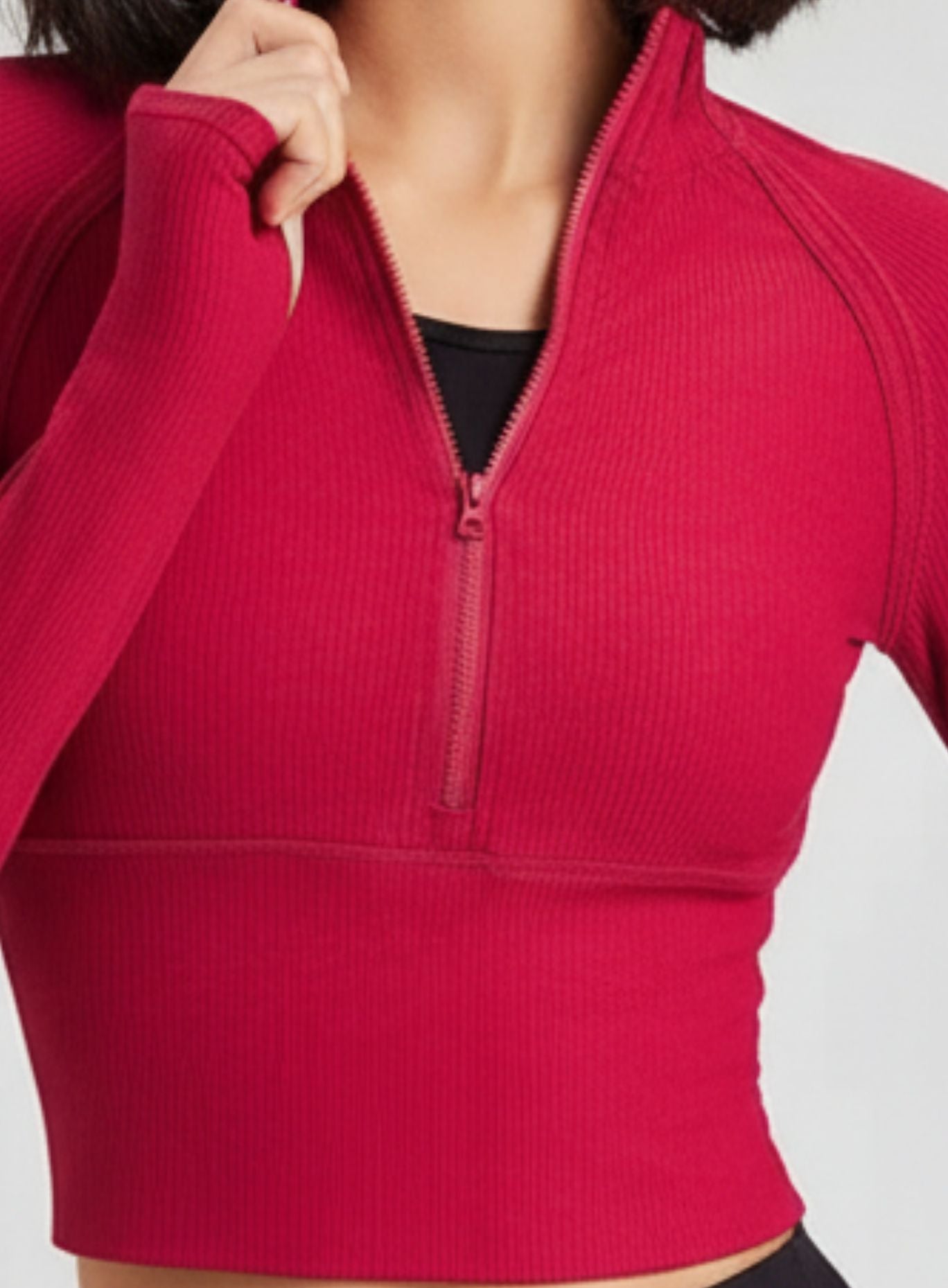 Close-up of red ribbed half-zip mock-neck yoga top, breathable quick-dry fabric.