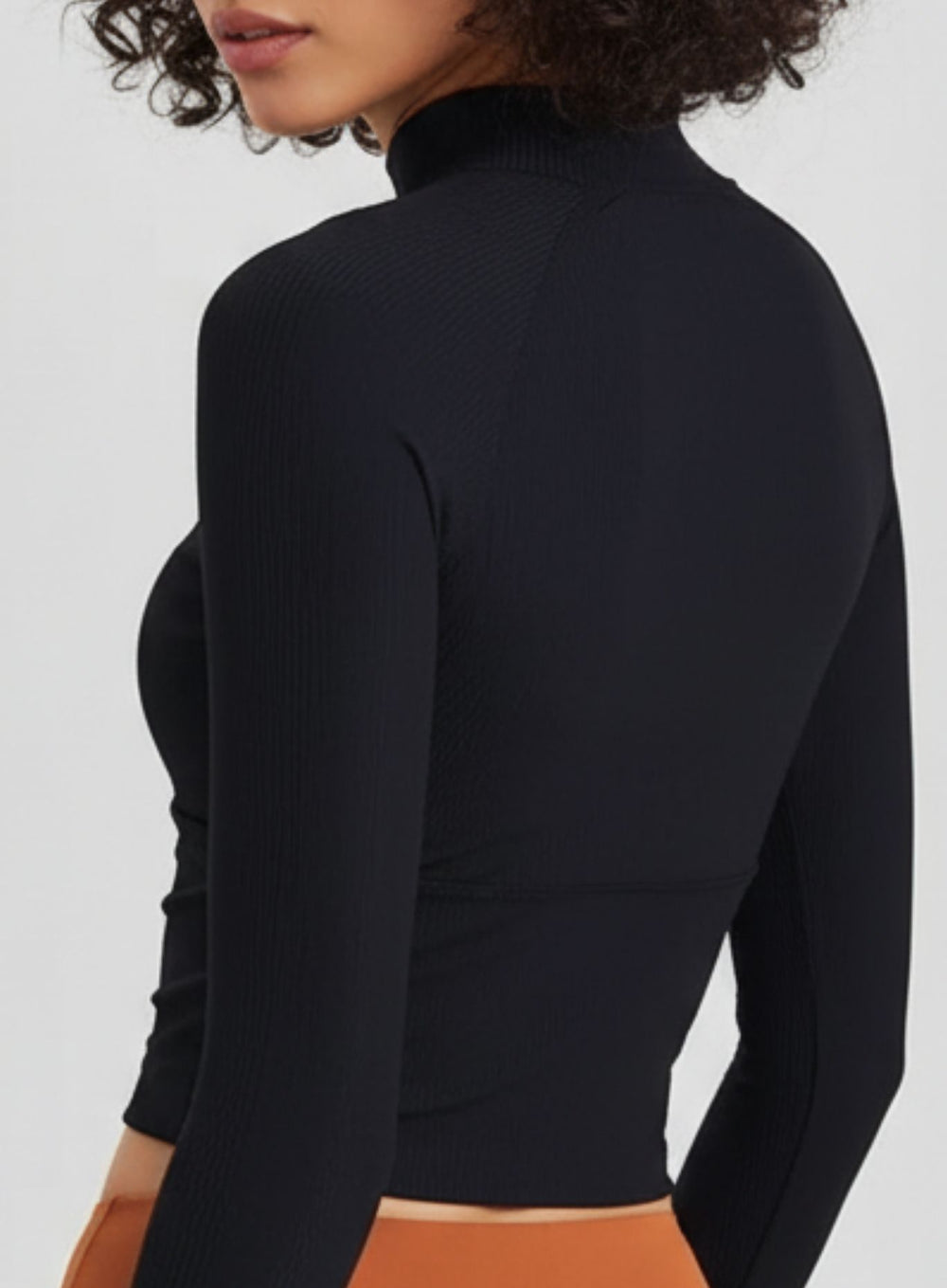 Black long-sleeve yoga crop, smooth back panel and fitted hem, performance fabric.