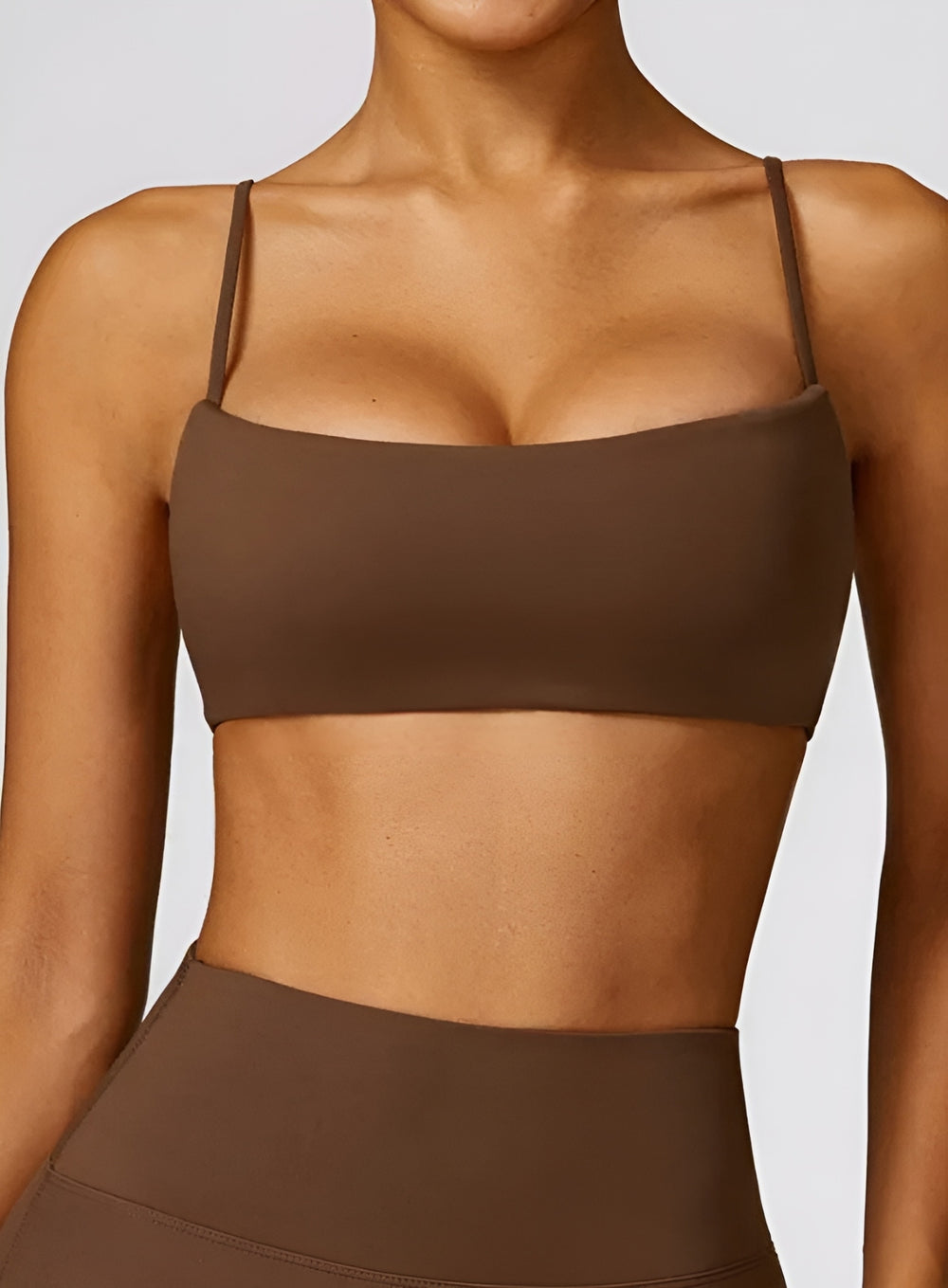 Woman wearing the CloudSense Seamless Sling Bra in black — open-back seamless sports bra with thin sling straps, sculpting fit, and smooth activewear fabric. | Vectorsportswear