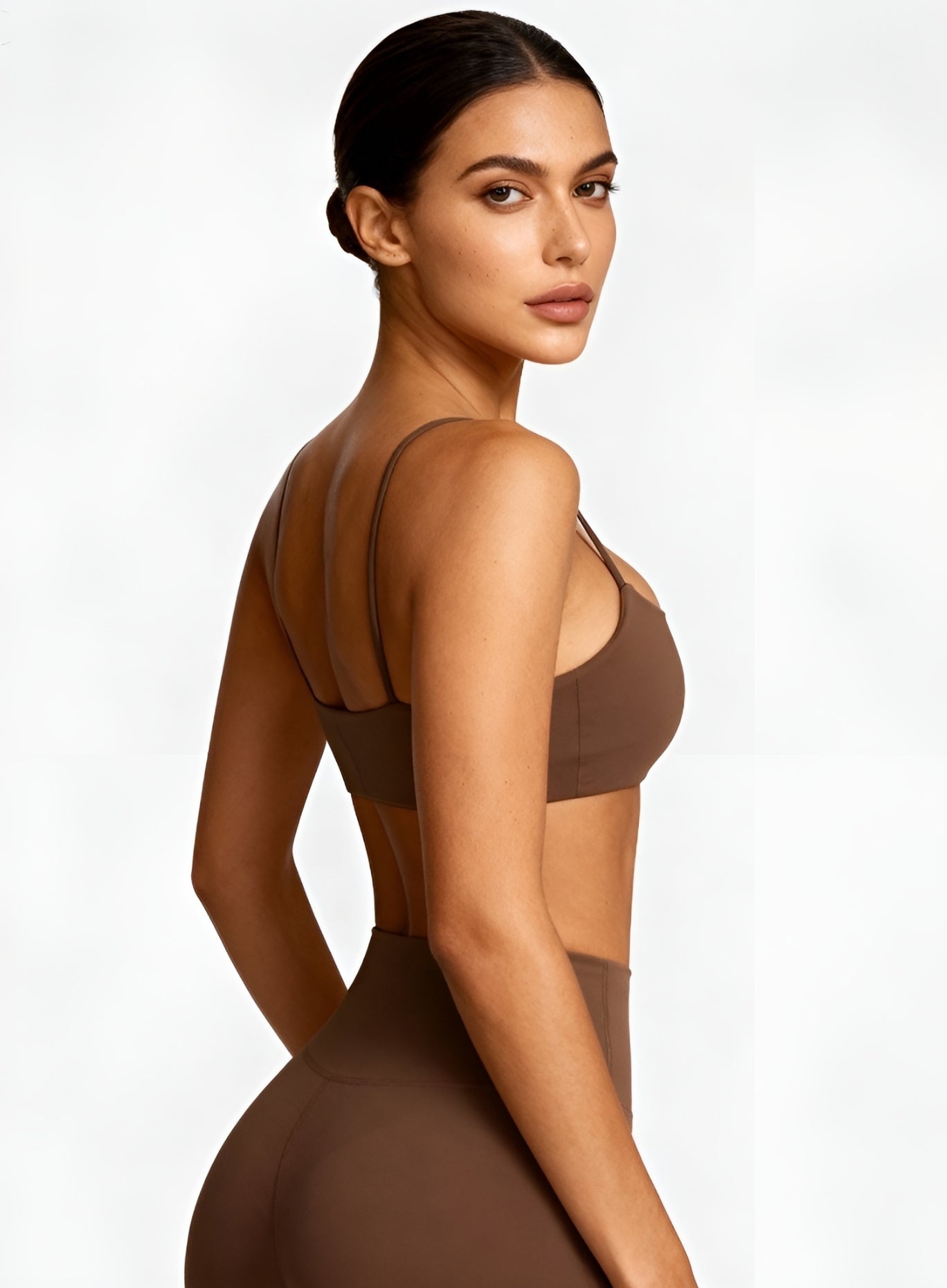 Side view of model wearing black CloudSense Seamless Sling Bra — seamless open-back design with thin sling straps and sculpting performance fabric. |  Vectorsportswear