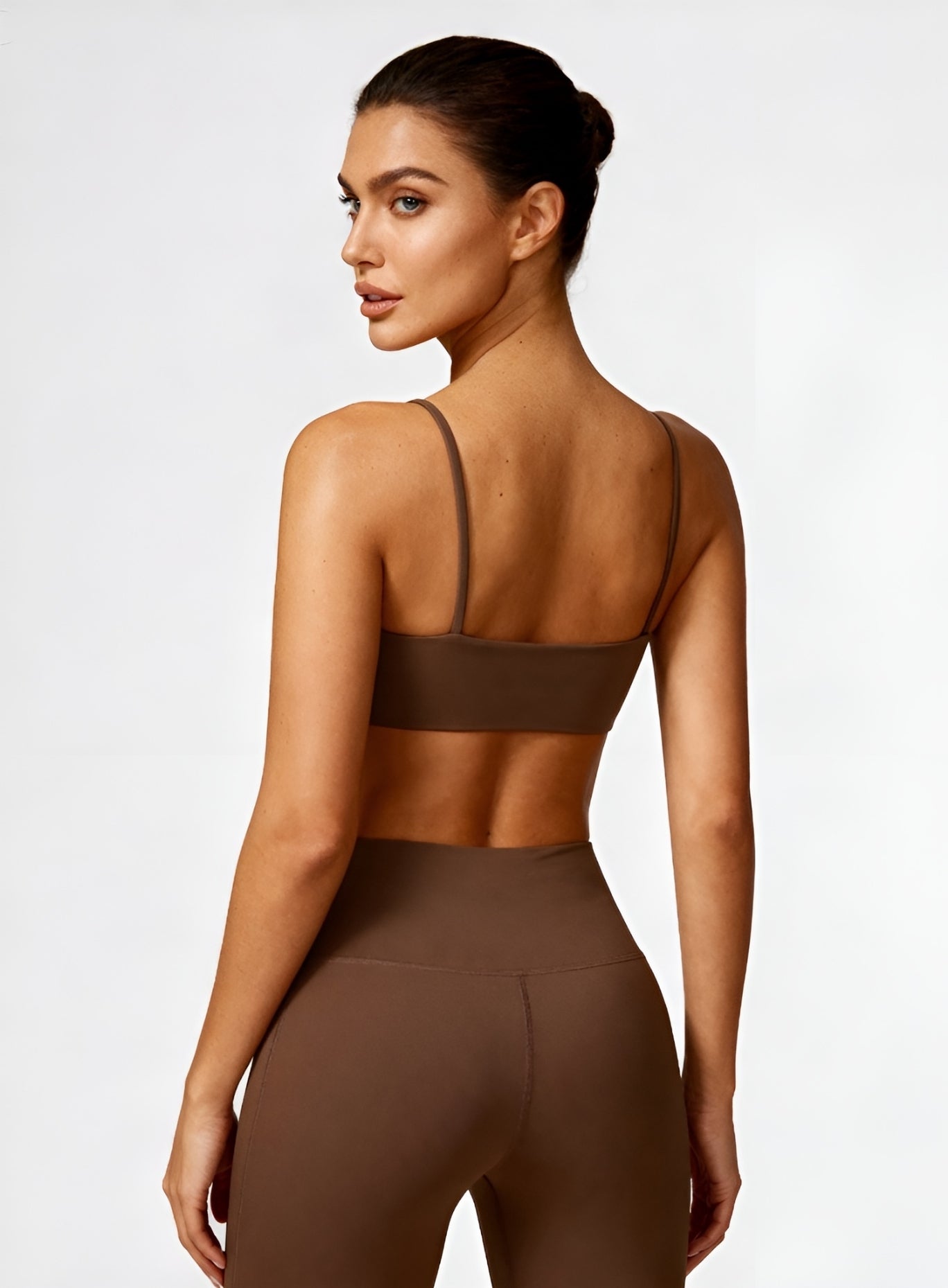 Rear view of model wearing black CloudSense Seamless Sling Bra — seamless open-back design with thin sling straps and sculpting performance fabric. | Vector Sportswear