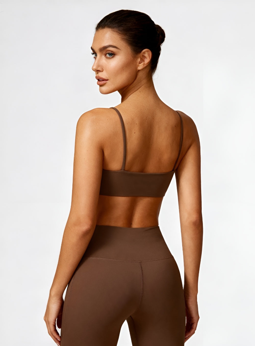 Rear view of model wearing black CloudSense Seamless Sling Bra — seamless open-back design with thin sling straps and sculpting performance fabric. | Vector Sportswear