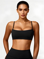 Woman wearing the CloudSense Seamless Sling Bra in black — open-back seamless sports bra with thin sling straps, sculpting fit, and smooth activewear fabric. | Vectorsportswear