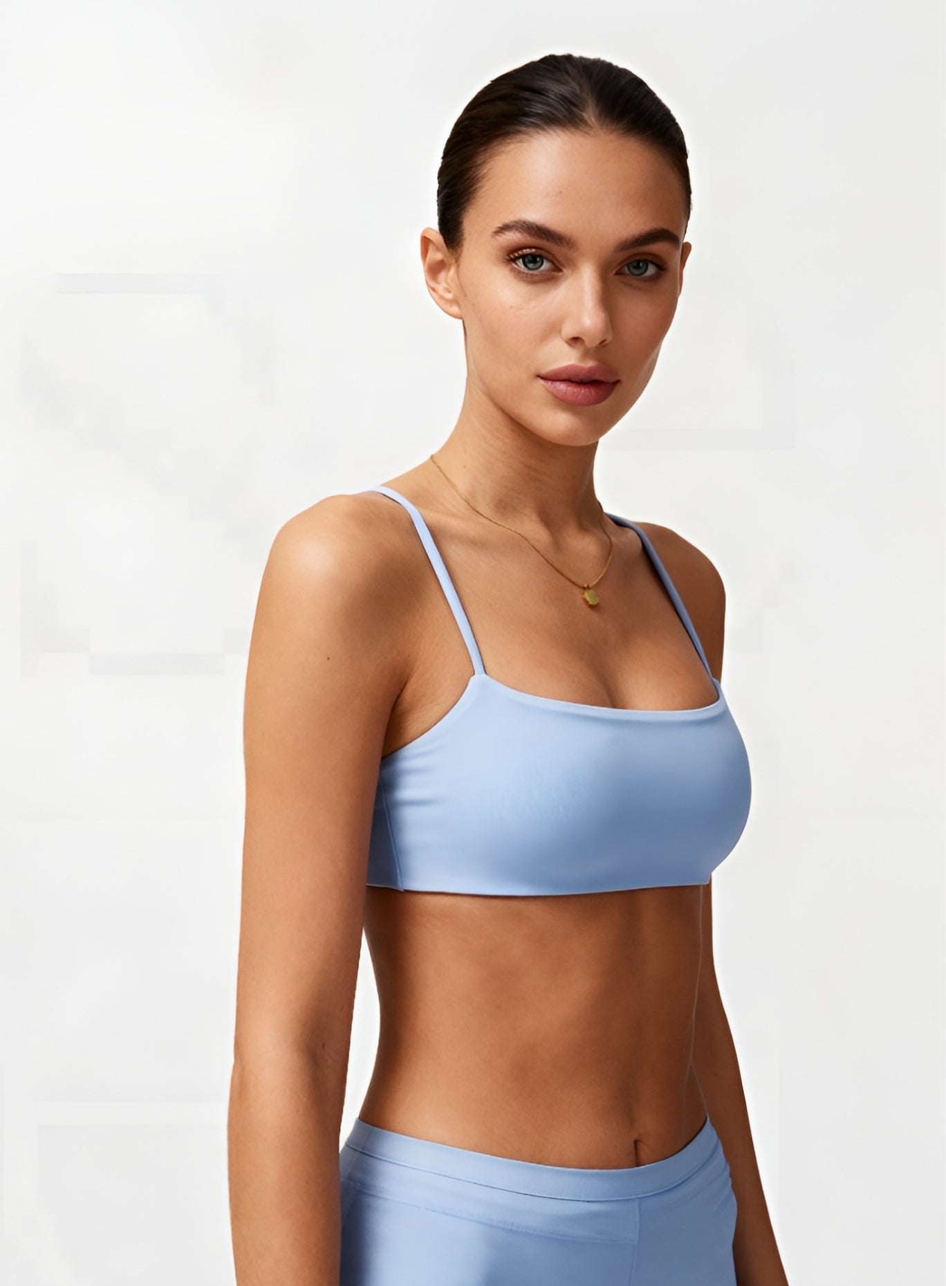 Woman wearing the CloudSense Seamless Sling Bra in black — open-back seamless sports bra with thin sling straps, sculpting fit, and smooth activewear fabric. | Vectorsportswear