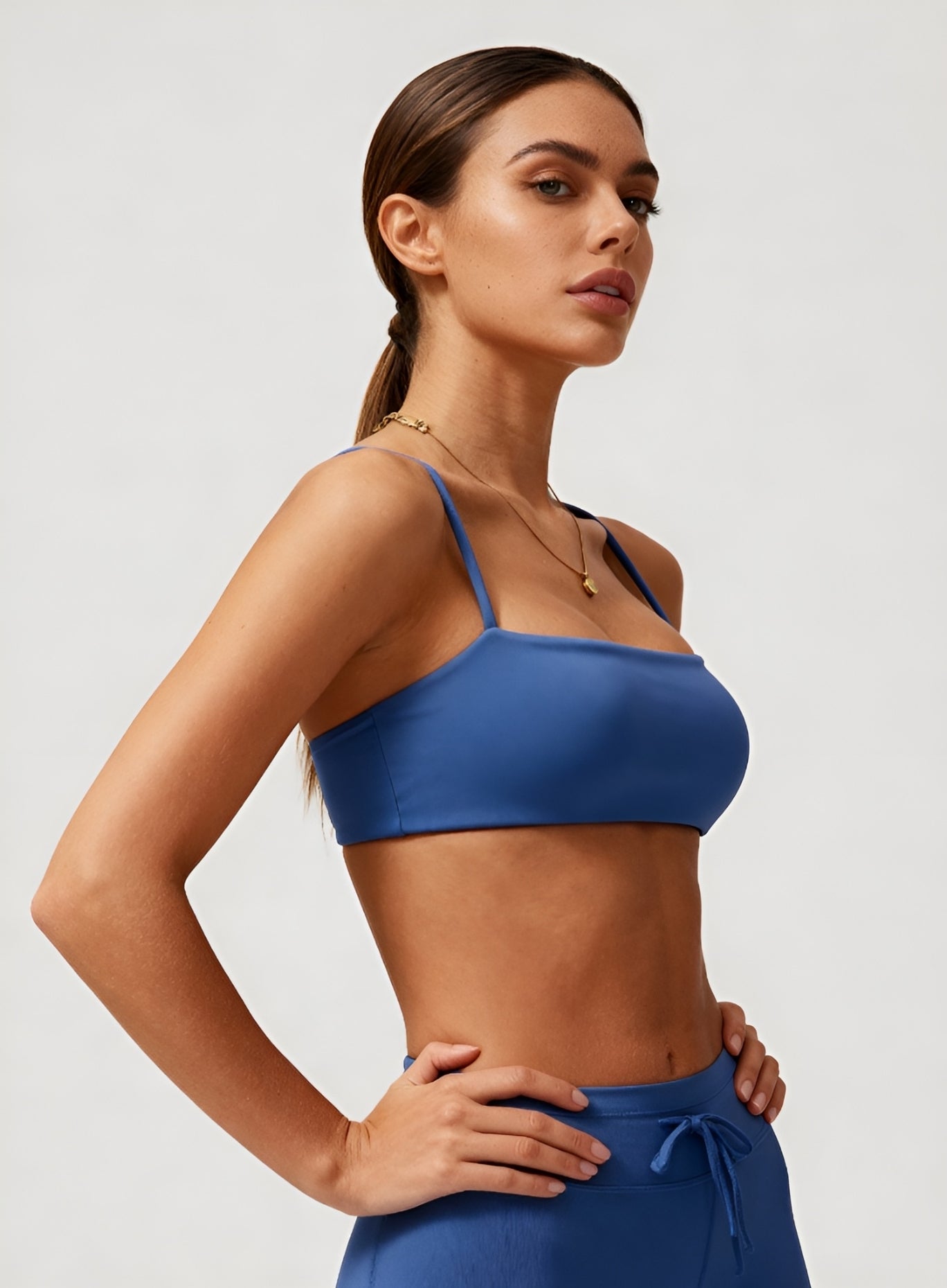 Woman wearing the CloudSense Seamless Sling Bra in black — open-back seamless sports bra with thin sling straps, sculpting fit, and smooth activewear fabric. | Vectorsportswear